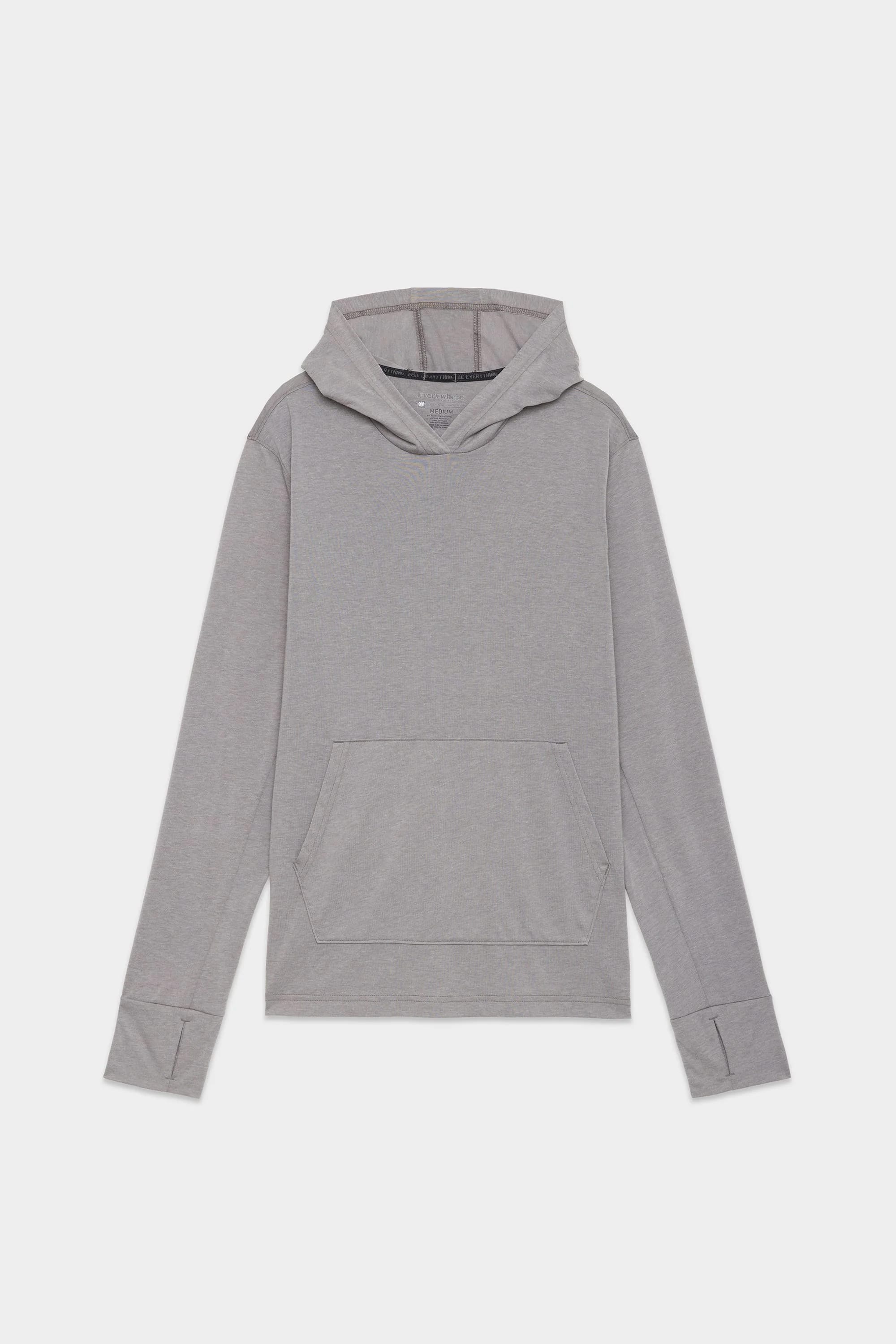 The 686 Mens Everywhere drirelease® Long Sleeve Hooded Tech Tee in light grey, featuring a front kangaroo pocket and thumb holes on the cuffs, is displayed laid flat on a white background.