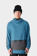 A person wears the 686 Mens Ultra Thermal Fleece Hoody, a blue and gray merino wool blend pullover by 686, paired with a black beanie. They stand facing forward against a plain light background with hands relaxed by their sides.