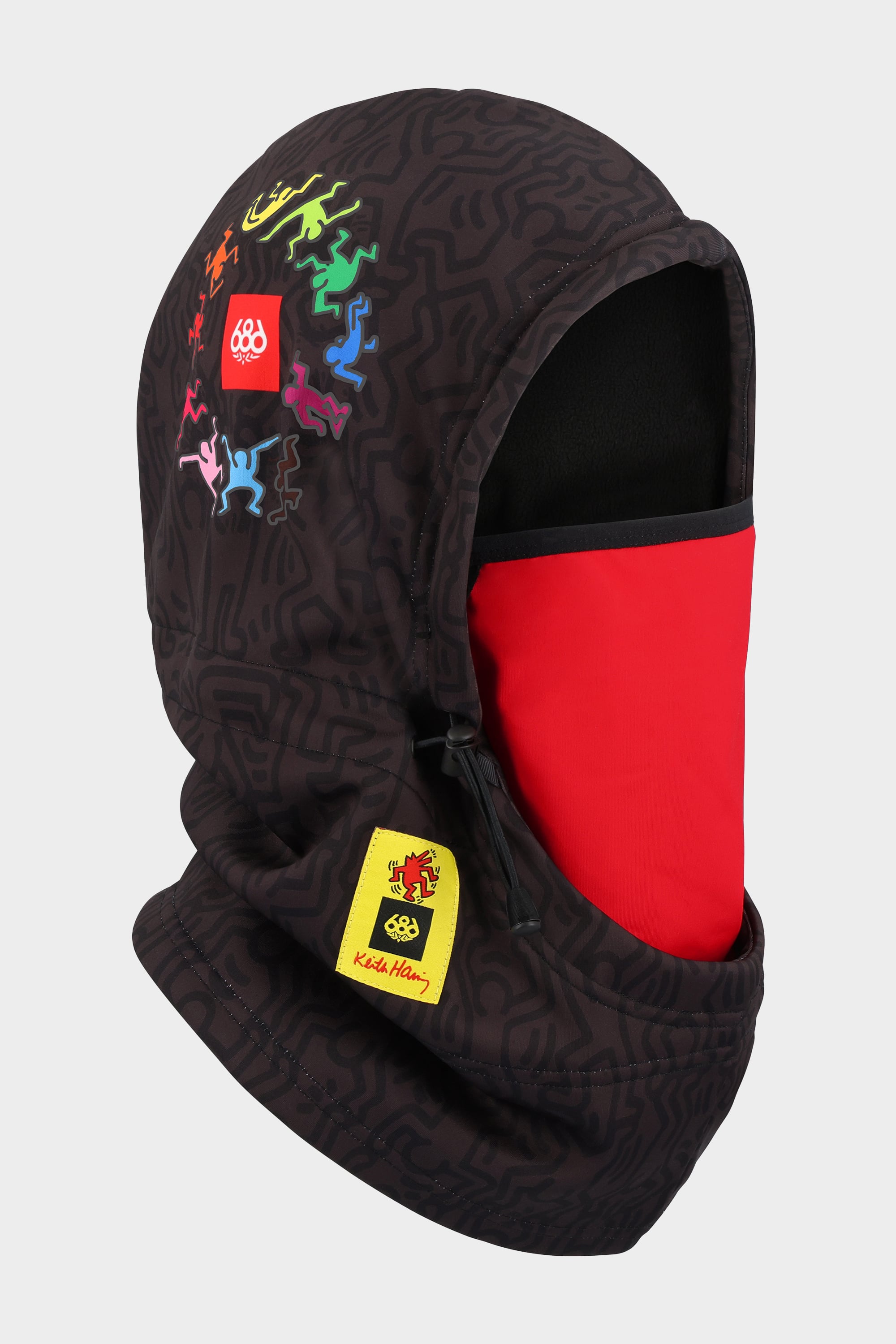 The 686 Patriot Bonded Hood by 686 is a black hooded face mask made from lightweight DWR fleece. It features abstract patterns, colorful human figures, a thinner fleece hood, and a yellow Keith Haring lion patch—a unique headwear accessory.
