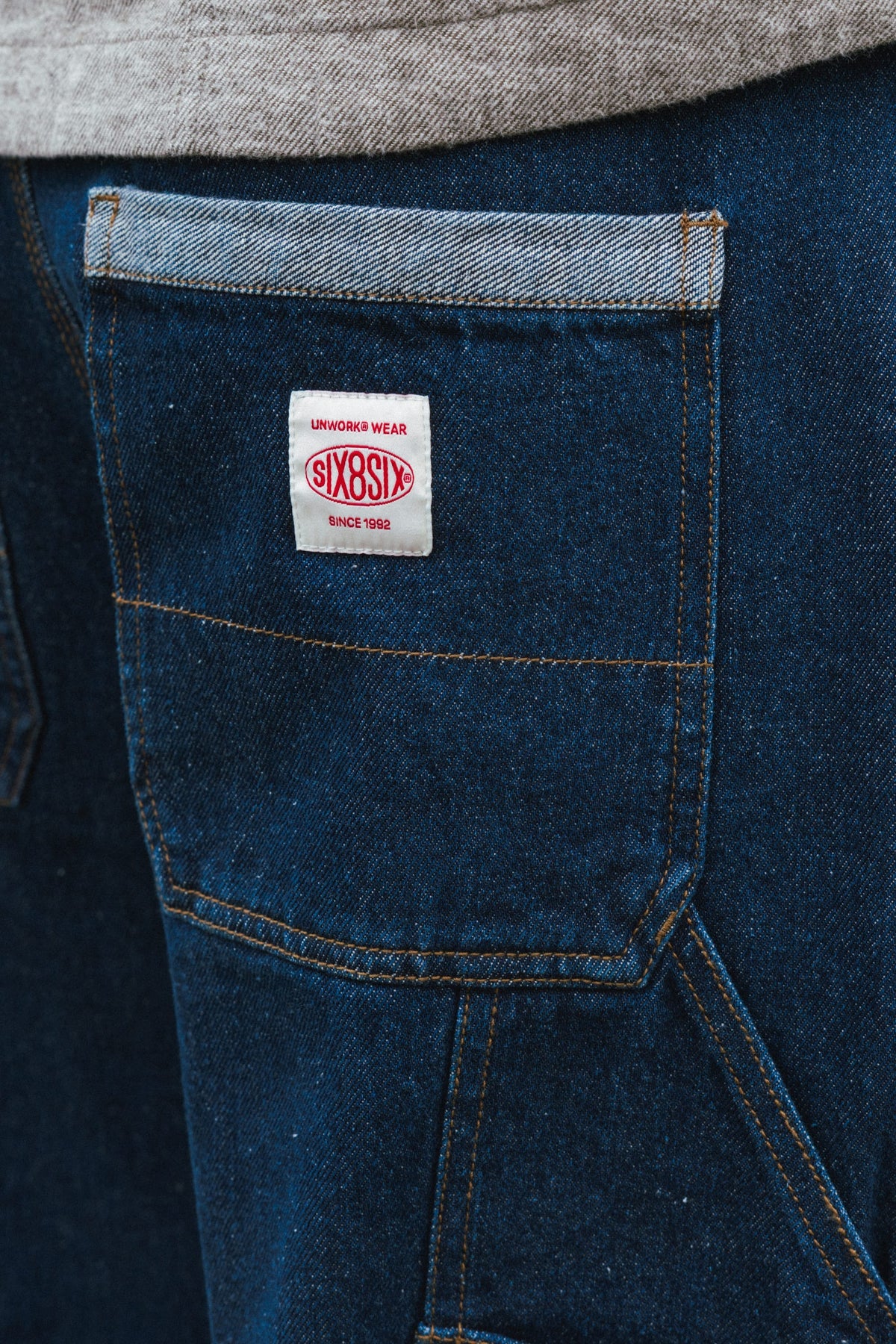 Dark blue 686 Men’s Unwork® Hammerhead Denim Pant work pants featuring a back pocket with a white branded patch that reads UNWORK WEAR SIX8SIX SINCE 1992.