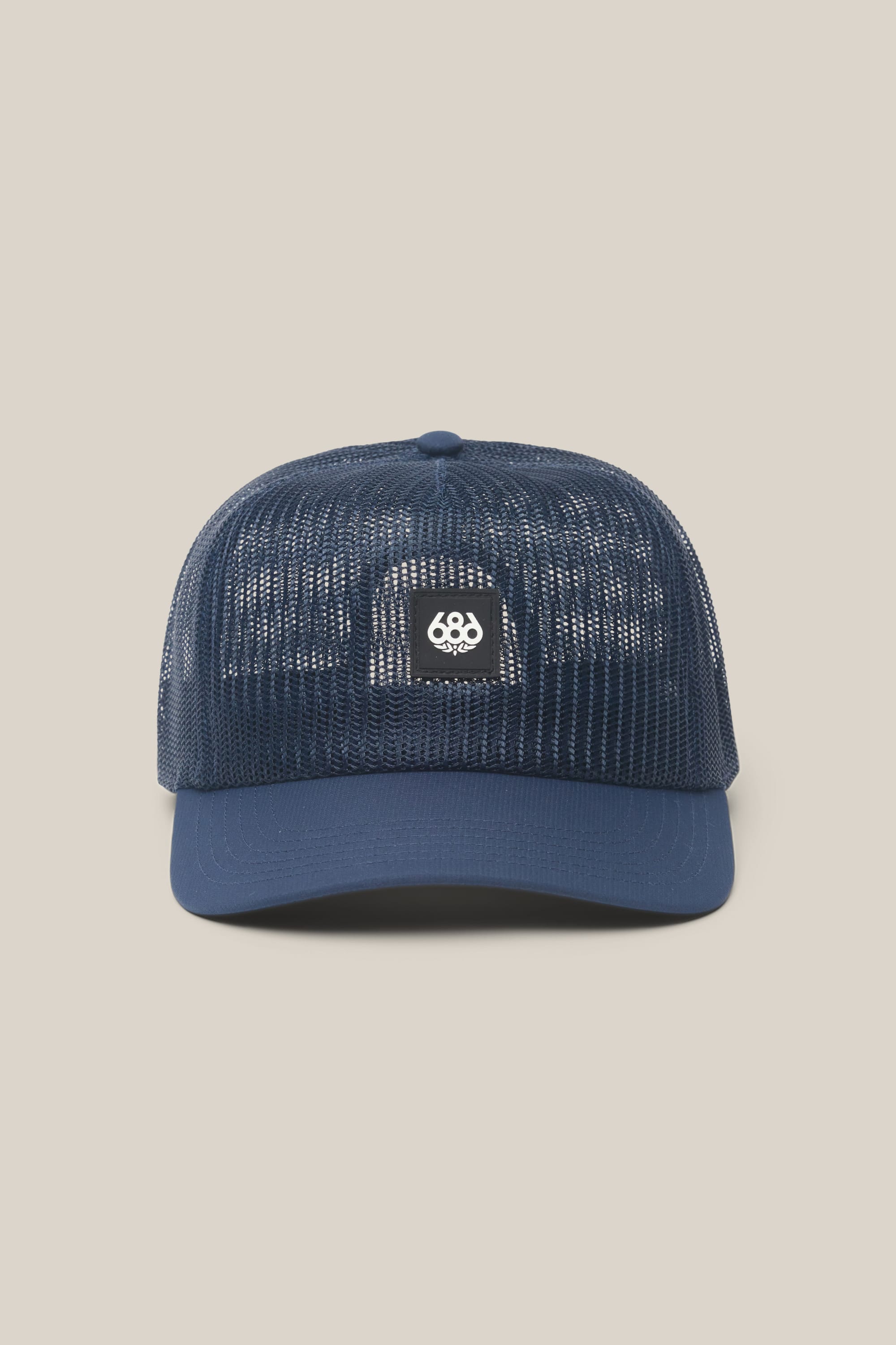 The 686 High-Pro Knockout Structured 5 Panel Hat by 686 is a navy blue men's mesh hat with a solid brim and a small square "686" patch on the front, shown against a plain beige background.