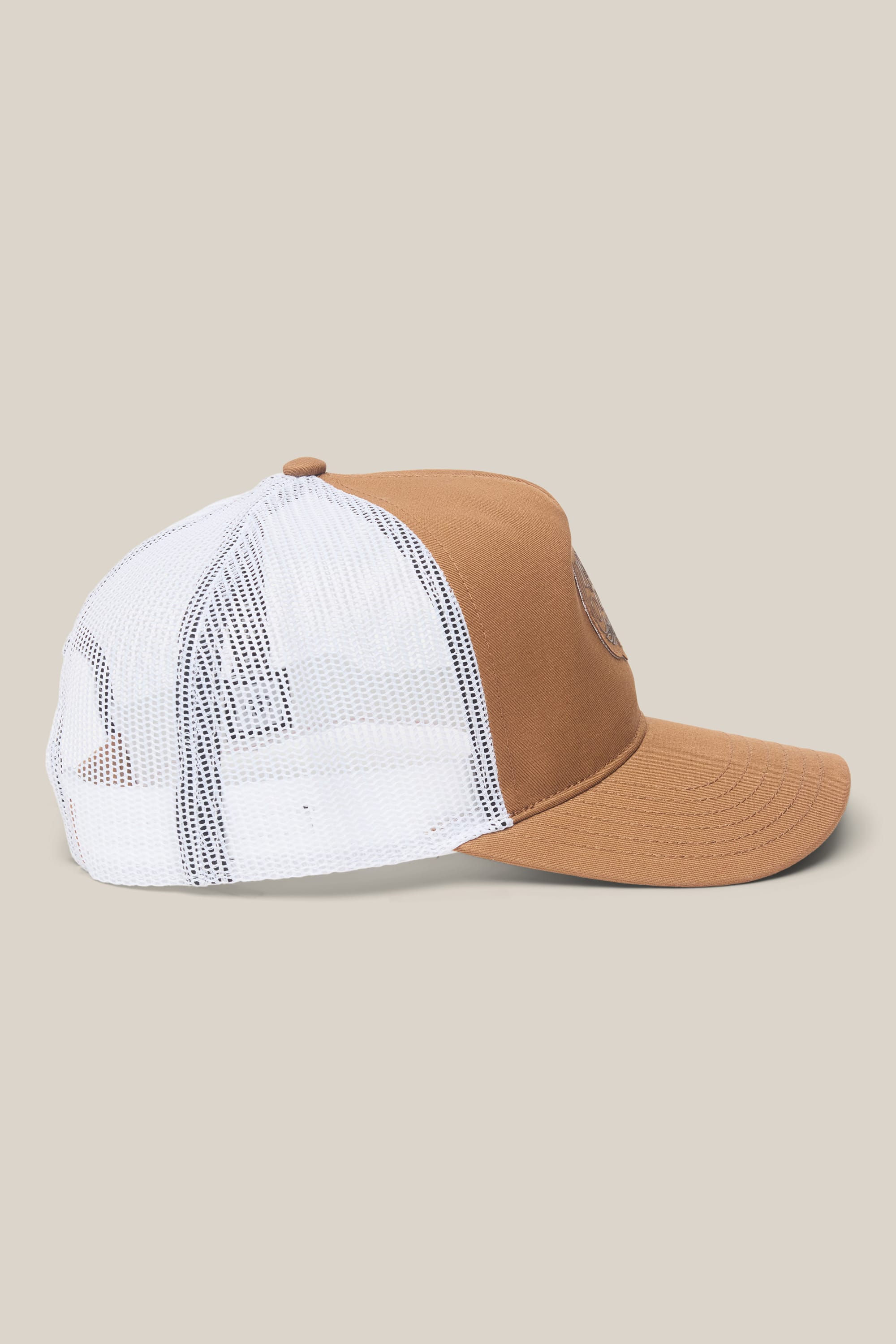 The 686 Mid-Pro Wreath Unstructured 5 Panel Mesh Hat by 686 is displayed in side profile on a beige background, showcasing its solid brown front and bill, along with a white mesh back and snap closure.