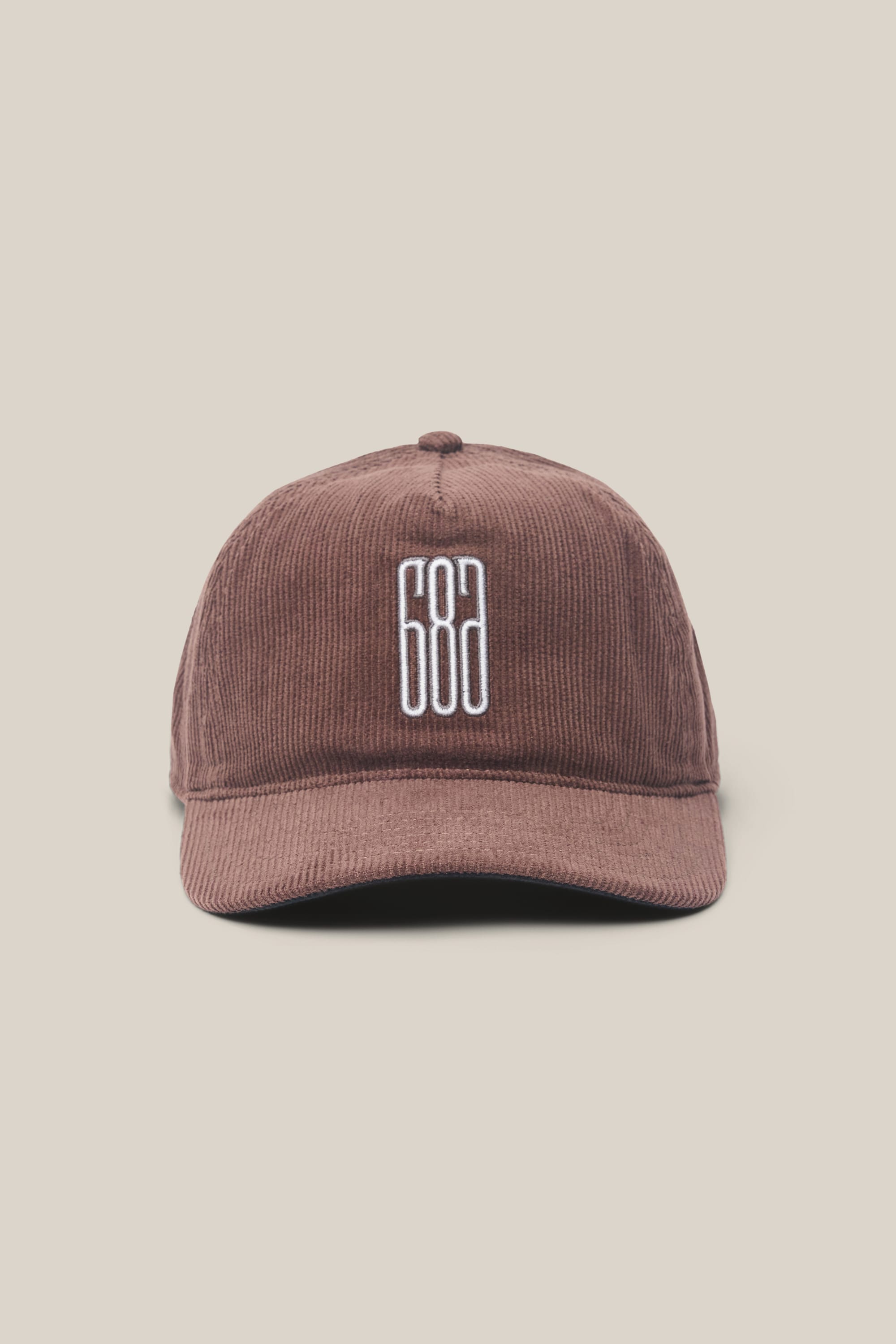 The 686 Mid-Pro Ghost Cord Unstructured 5 Panel Hat by 686 is a brown men's corduroy hat featuring white embroidered “686” numbers on the front, shown against a plain beige background.