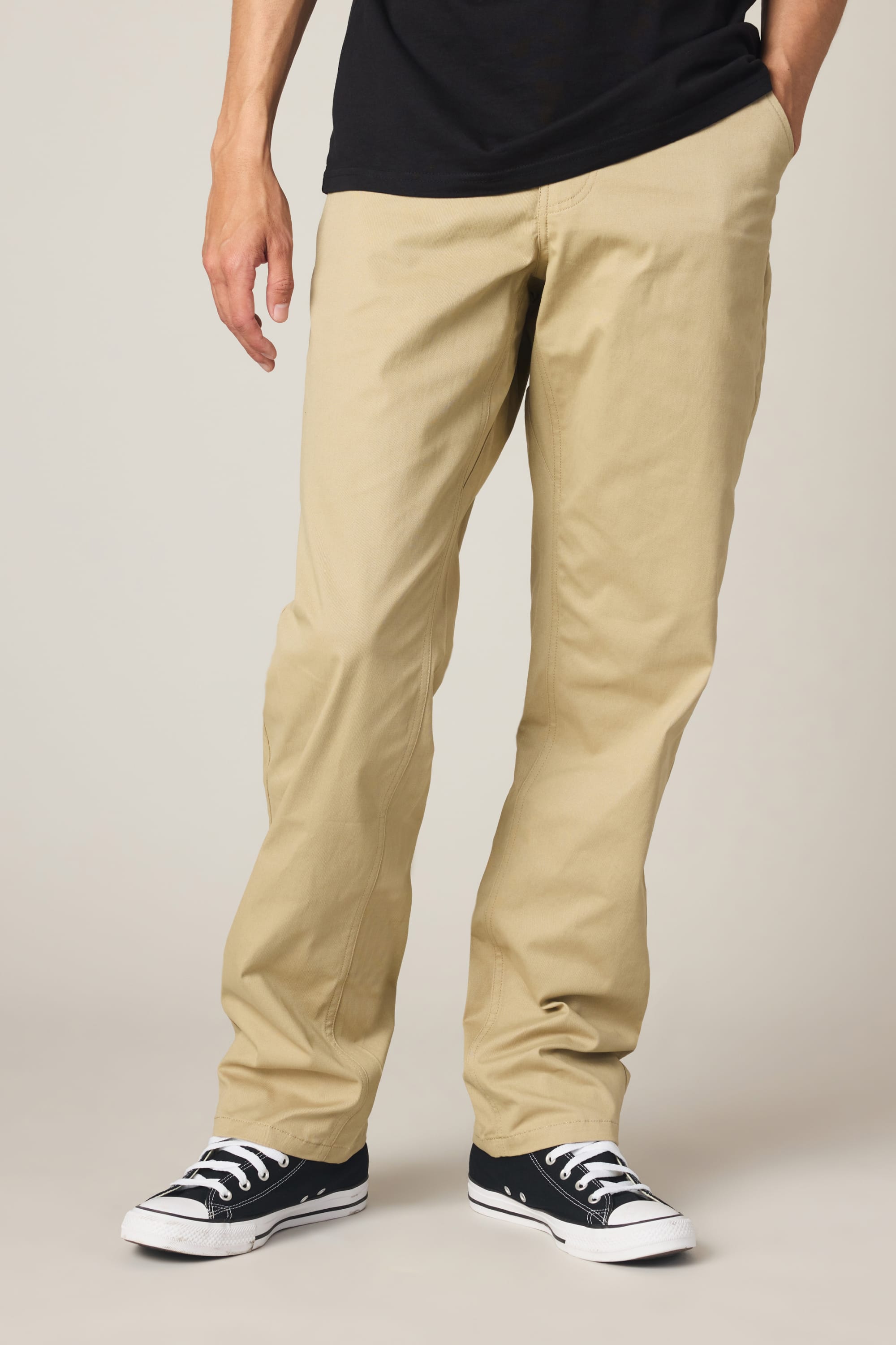 A person wearing 686 Men's Everywhere® Standard Pant - Relaxed Fit, a black t-shirt, and black-and-white sneakers is shown from the shoulders down against a light background.