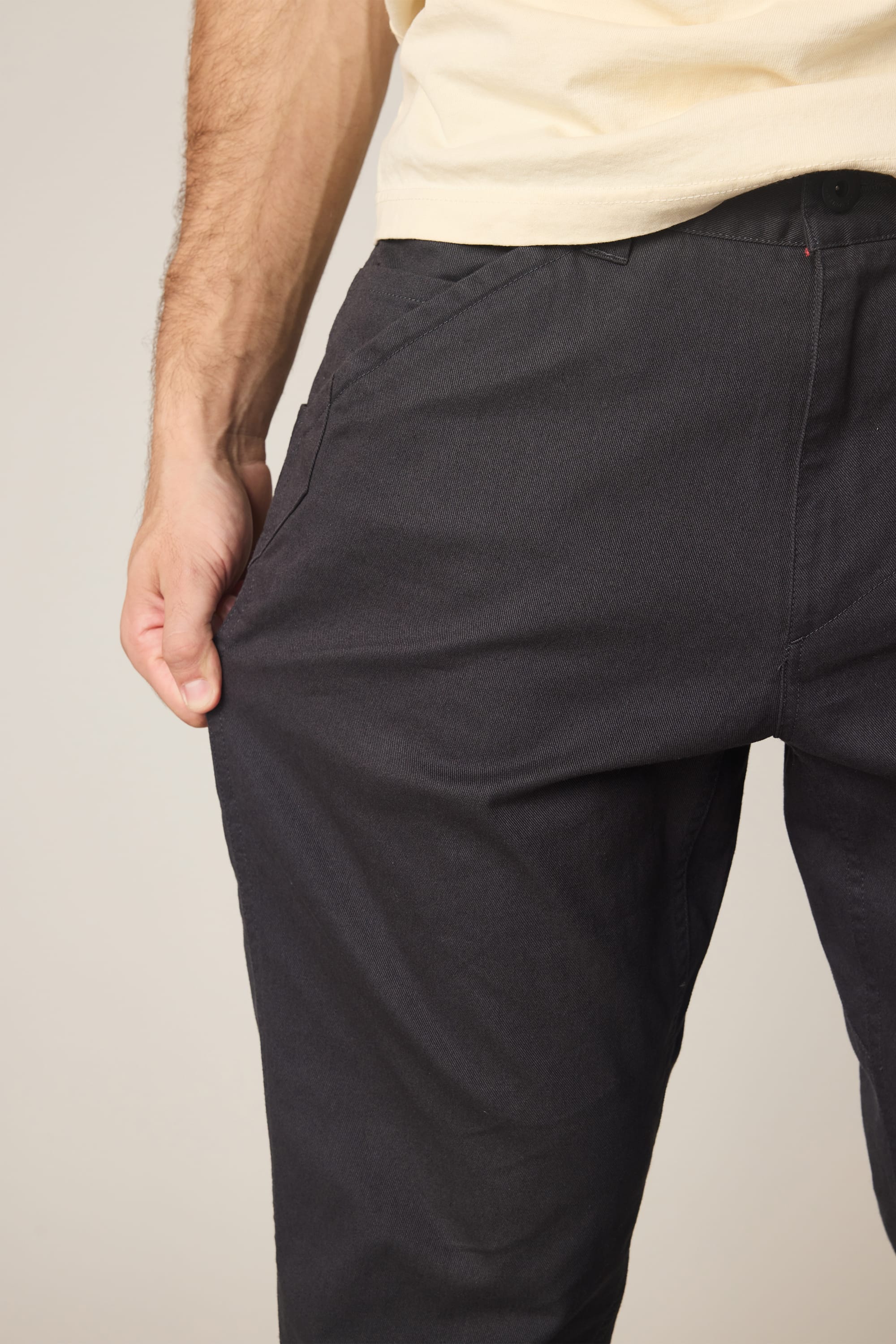 A person wearing the 686 Men's Unwork® Tradesman Pant - Relaxed Fit stands with one hand in their pocket, highlighting the waist and upper legs.