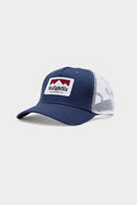 The 686 Trucker Hat by 686 features a blue and white design, mesh back, and a front patch reading SixEightSix Outdoor Supply Co. with a red mountain graphic. It is shown on a light gray background.