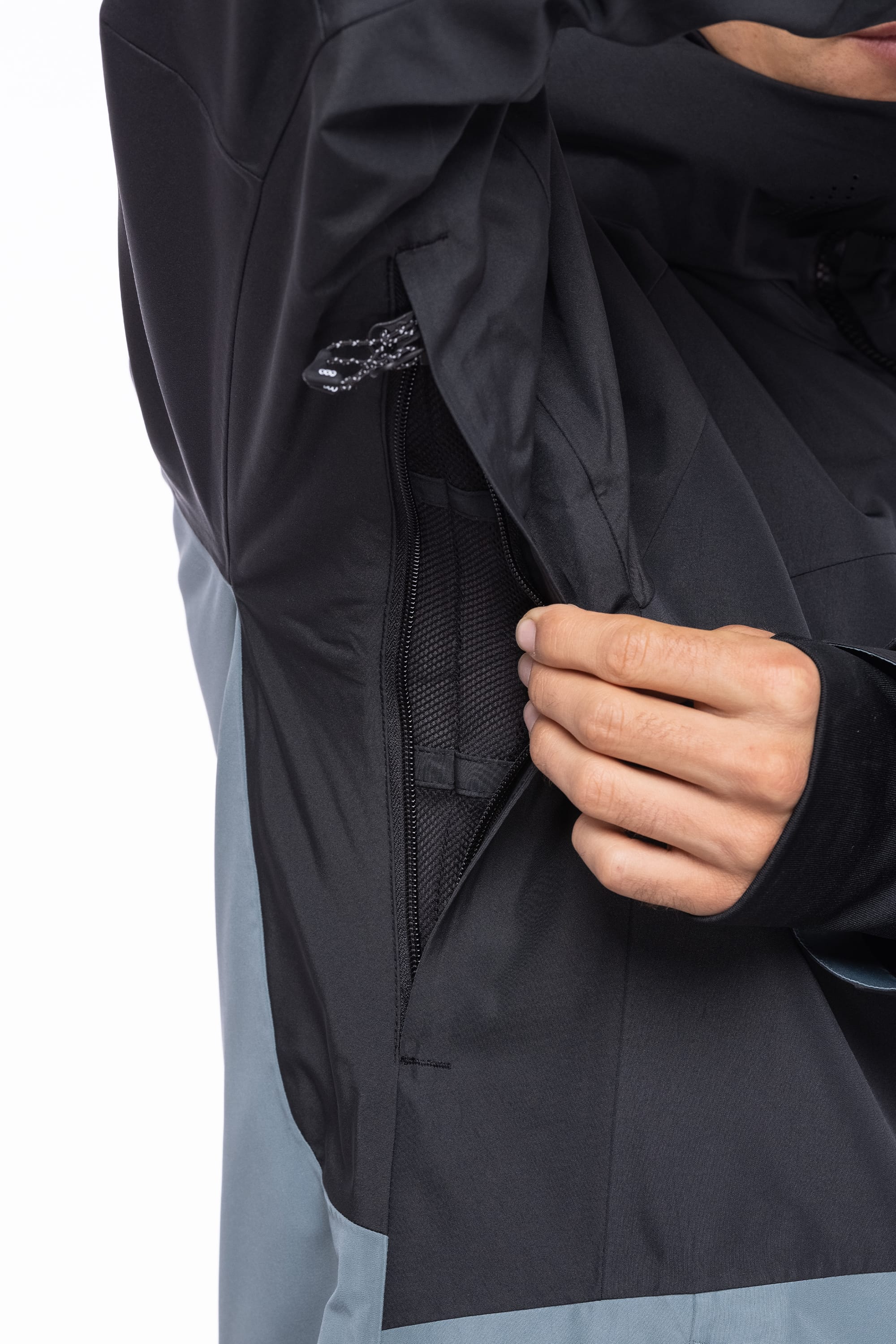 A person opens a zippered underarm vent on the 686 Men's Hydrastash Reserve Insulated Jacket, revealing the mesh lining inside.