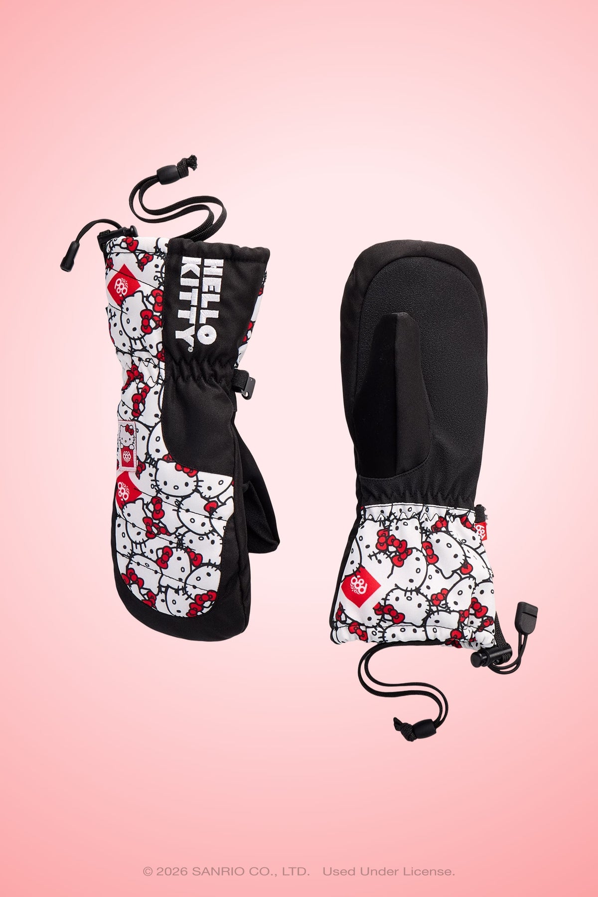 Two black 686 Youth Heat Insulated Mitts are pictured on a pink background, one displaying the front and the other showing the palm side. Both mittens feature adjustable cords at the wrists.