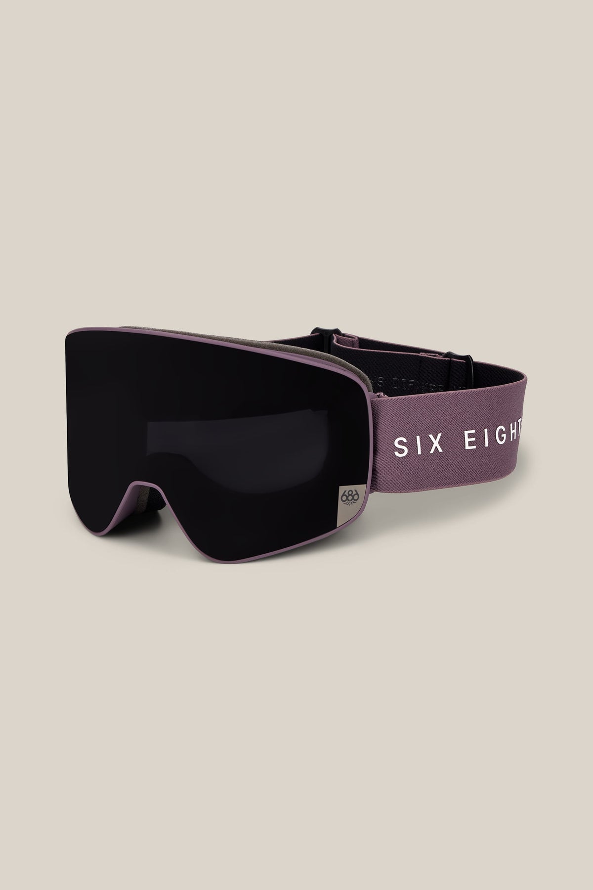 The 686 SMARTY® Magnetic Goggle by 686 features a purple frame with a black lens and an adjustable strap displaying “SIX EIGHT” in white letters. The goggles are set against a plain, light beige background.