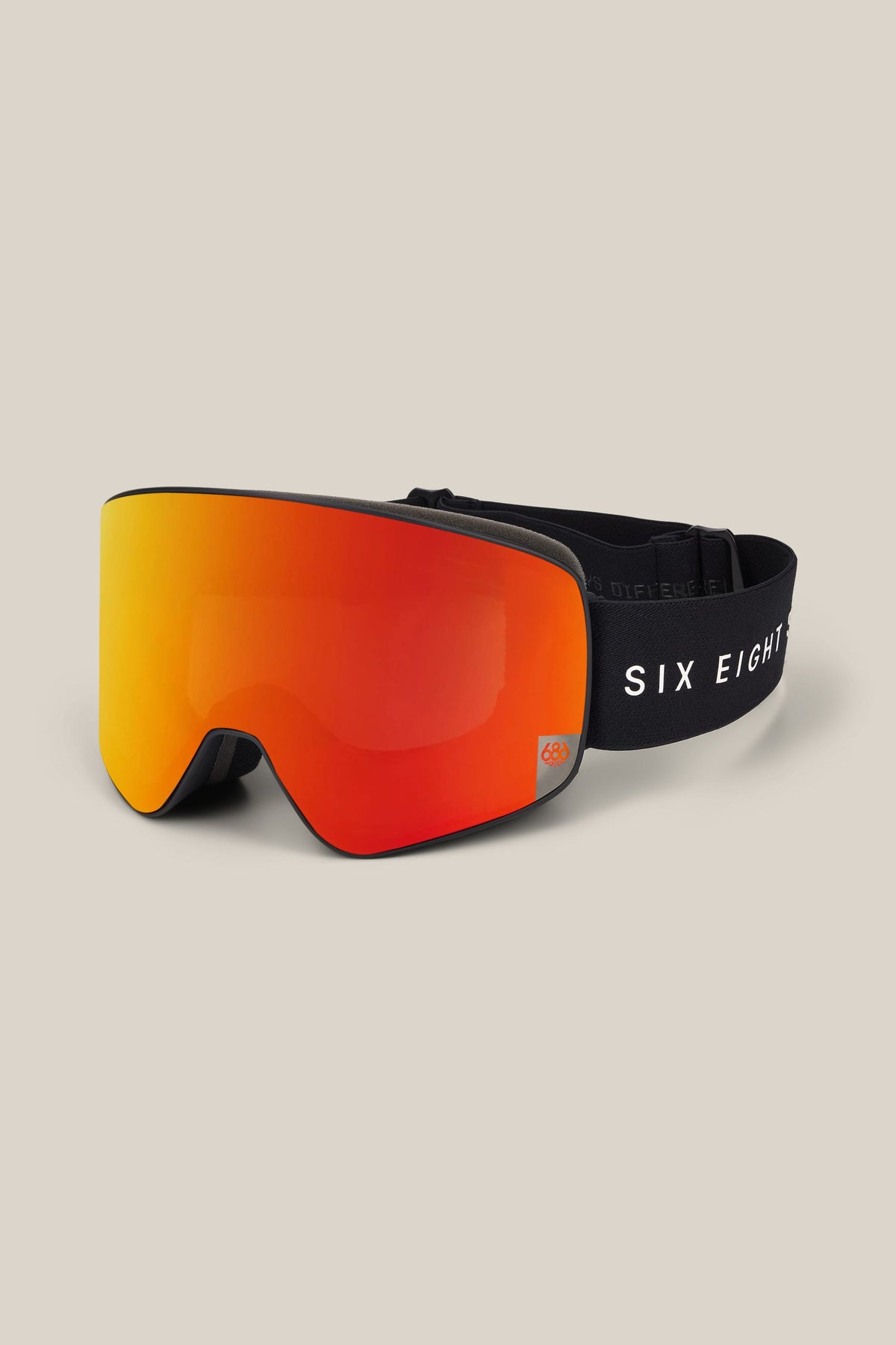 The 686 SMARTY® Magnetic Goggle features a reflective orange lens and a black strap emblazoned with the 686 logo. The goggles are displayed on a neutral beige background.