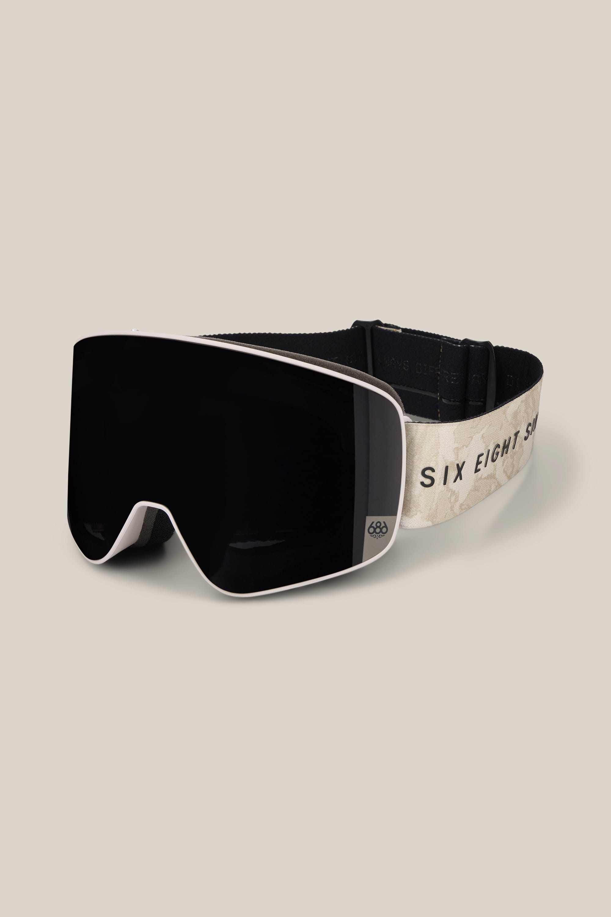 The 686 SMARTY® Magnetic Goggle features a wide, dark lens and an elastic strap adorned with a beige pattern and the text “SIX EIGHT SIX.” Branded by 686, these ski goggles are displayed on a neutral background.