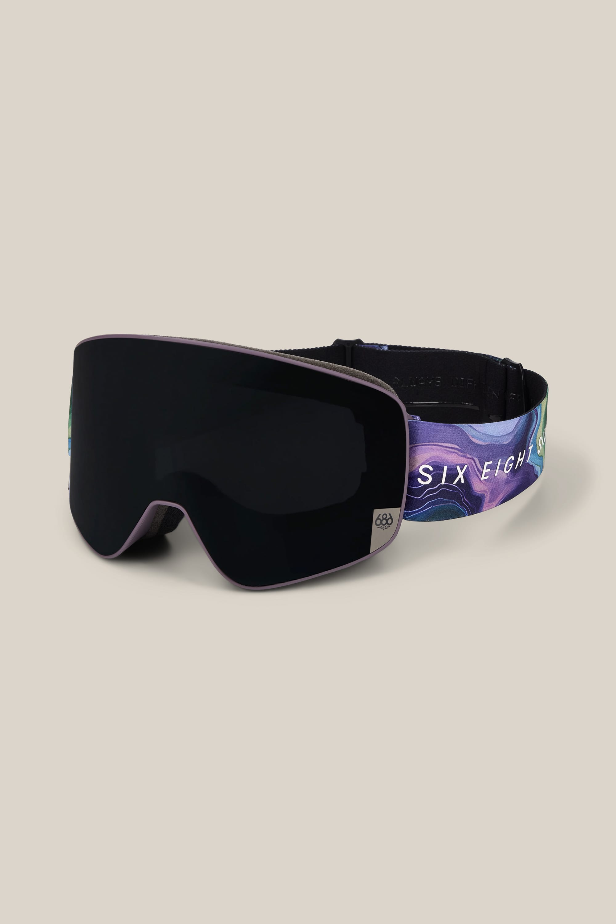 The 686 SMARTY® Magnetic Goggle by 686 features black lenses and a vibrant purple and blue strap with the text “SIX EIGH.” The goggles are shown against a plain beige background.