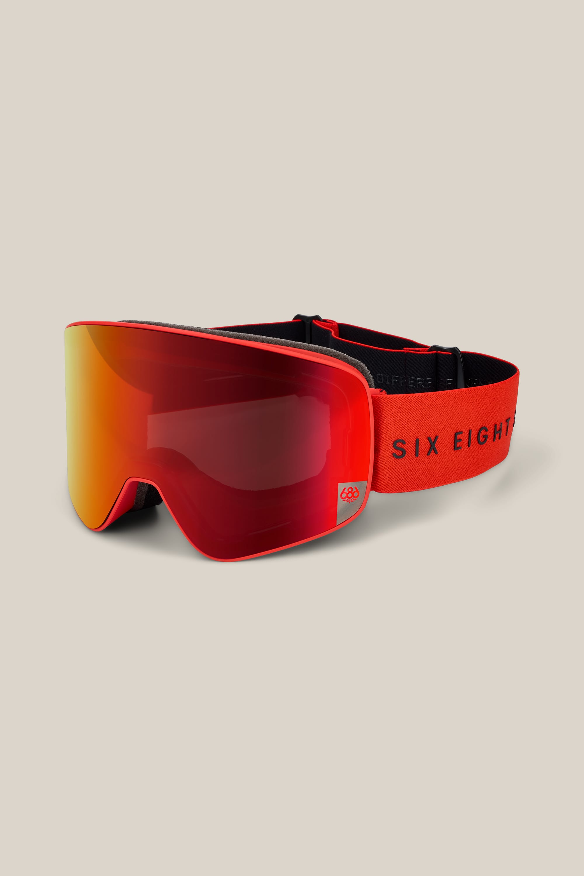 The 686 SMARTY® Magnetic Goggle by 686 is showcased with a reflective lens and a red adjustable strap featuring the text SIX EIGHT. The goggles are displayed against a plain beige background.