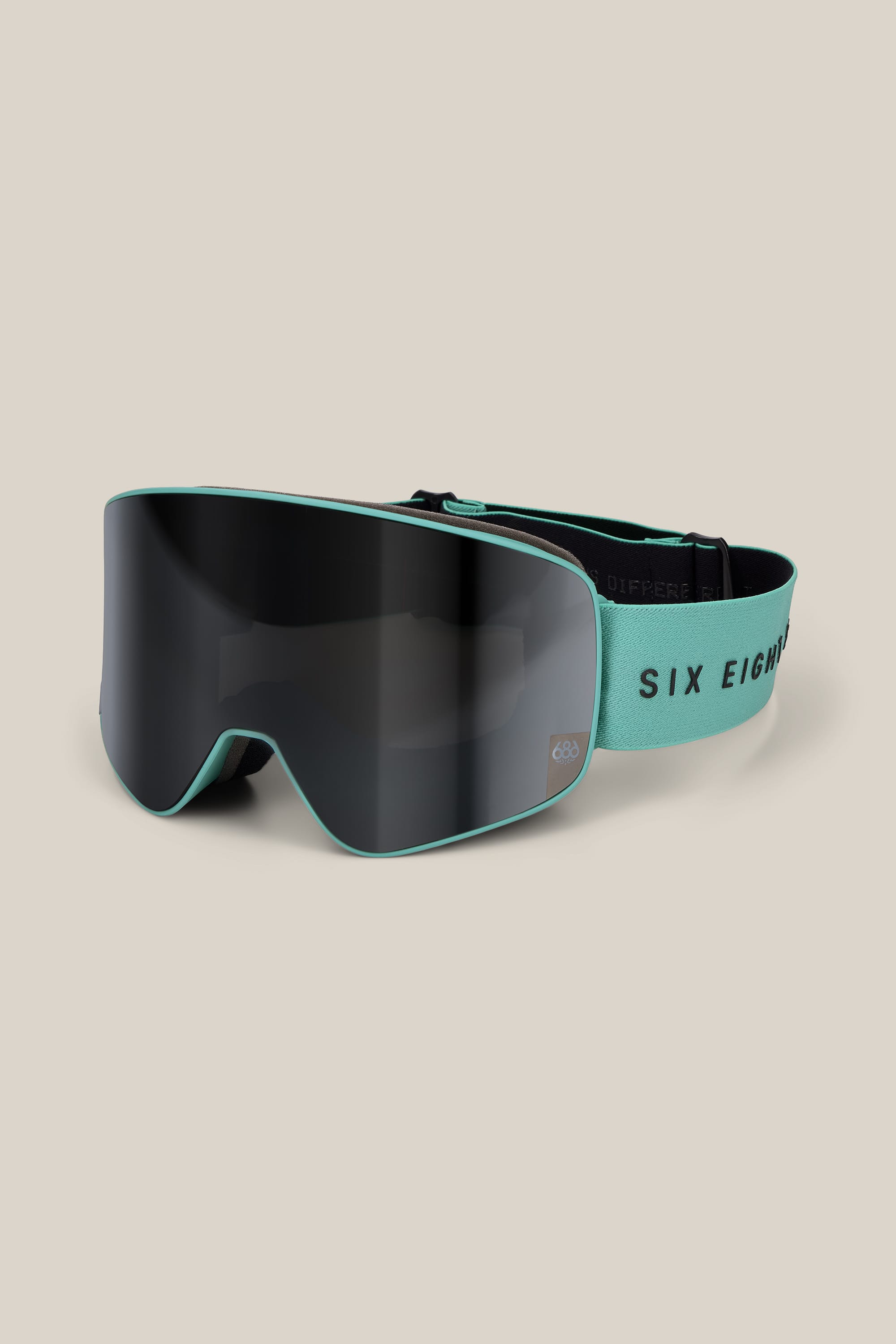 A pair of 686 SMARTY® Magnetic Goggles by 686, featuring a dark tinted lens and a mint green frame and strap with the text “SIX EIGHT” on the strap, displayed against a neutral background.