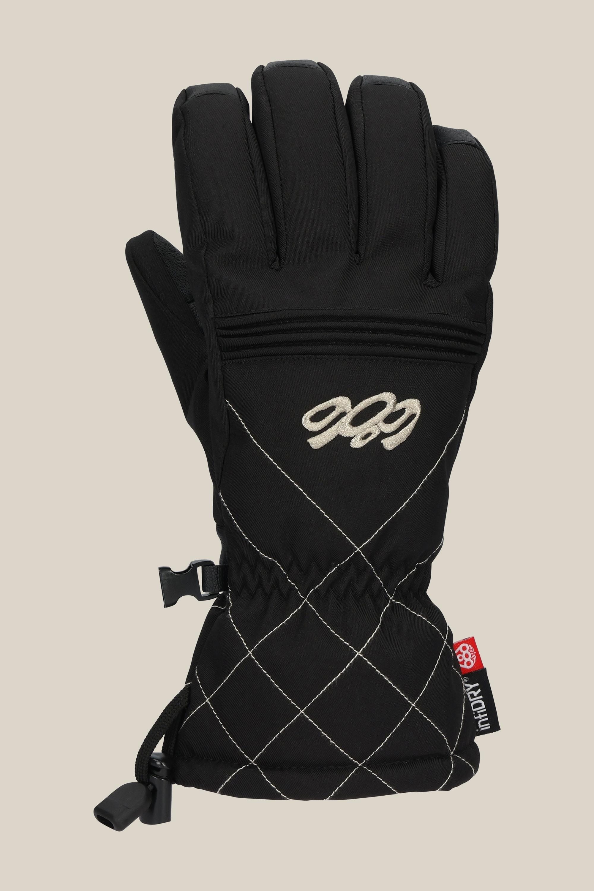 The 686 Womens Jubilee Glove by 686 is a black insulated PU glove featuring white diamond-pattern stitching, a back zipper, and a small red logo tag on the wrist, shown upright against a neutral background.