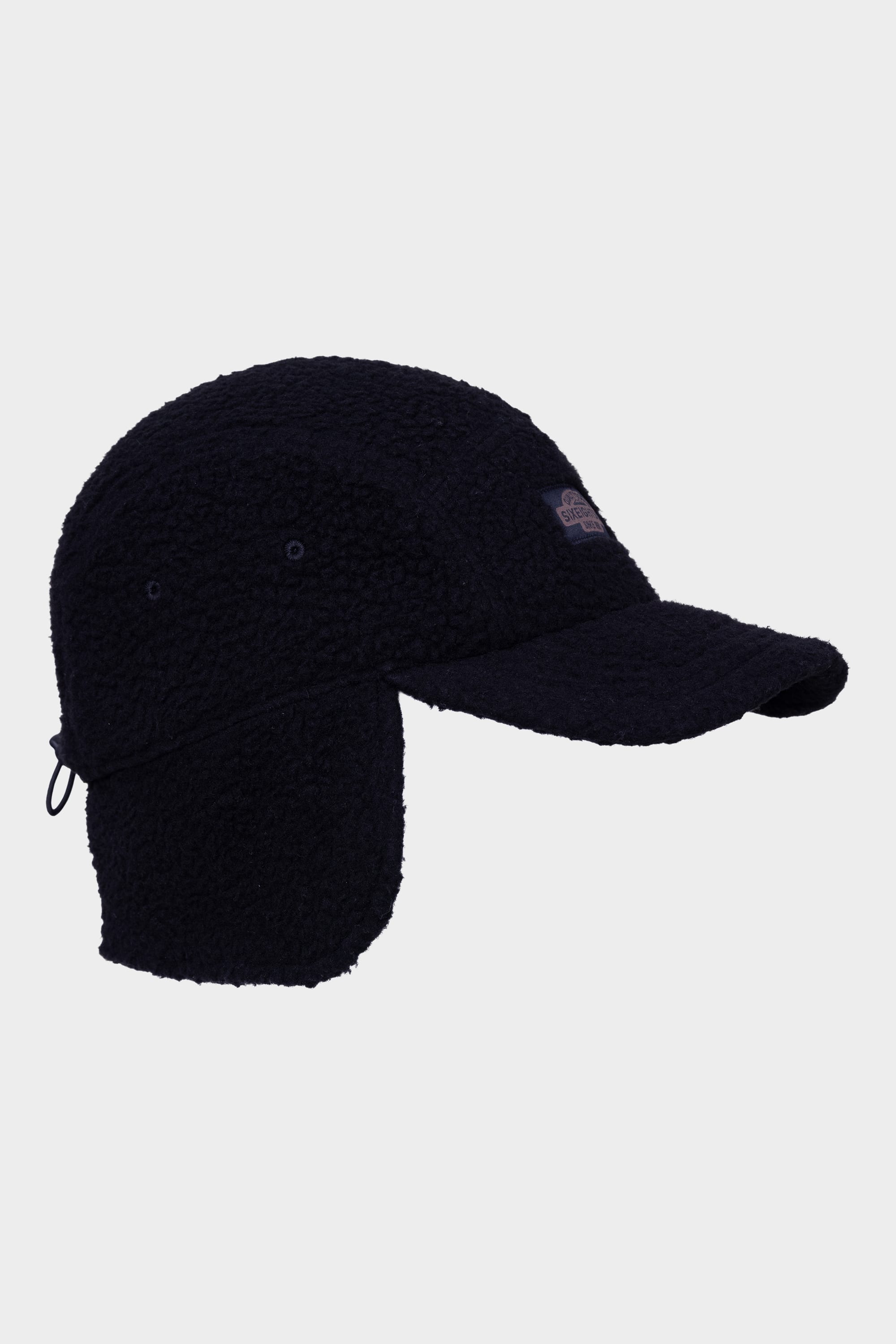 The 686 Fleece Camper Hat by 686 is a black winter cap with ear flaps and a curved brim, displayed in a side view against a plain white background.