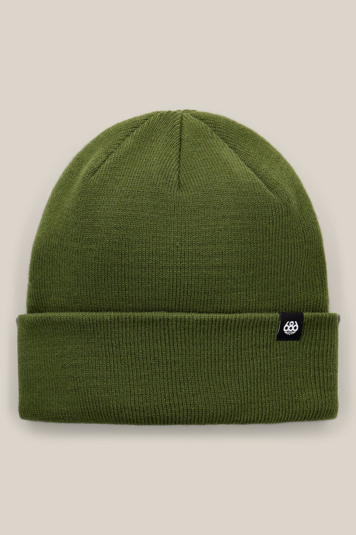 The 686 Standard Roll Up Beanie by 686 is a plain olive-green knit beanie with a folded brim, featuring a small black tag with a white logo on the side, displayed against a neutral beige background.