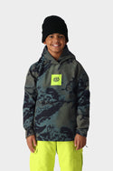 A smiling child wears the 686 Youth Waterproof Hoody by 686, featuring a blue and gray camo pattern with a neon yellow logo, paired with bright yellow pants and a black beanie, standing against a plain white background.