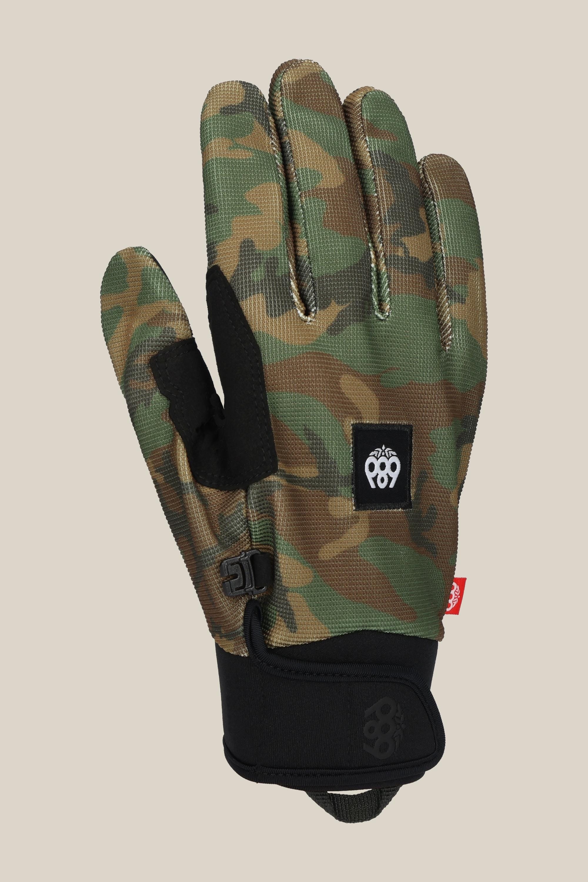 A 686 Mens Outlaw Pipe Glove by 686, featuring a camouflage pattern, black adjustable wrist strap, enhanced grip on the black palm patch, and a small logo patch on the back of the hand, displayed on a plain beige background.