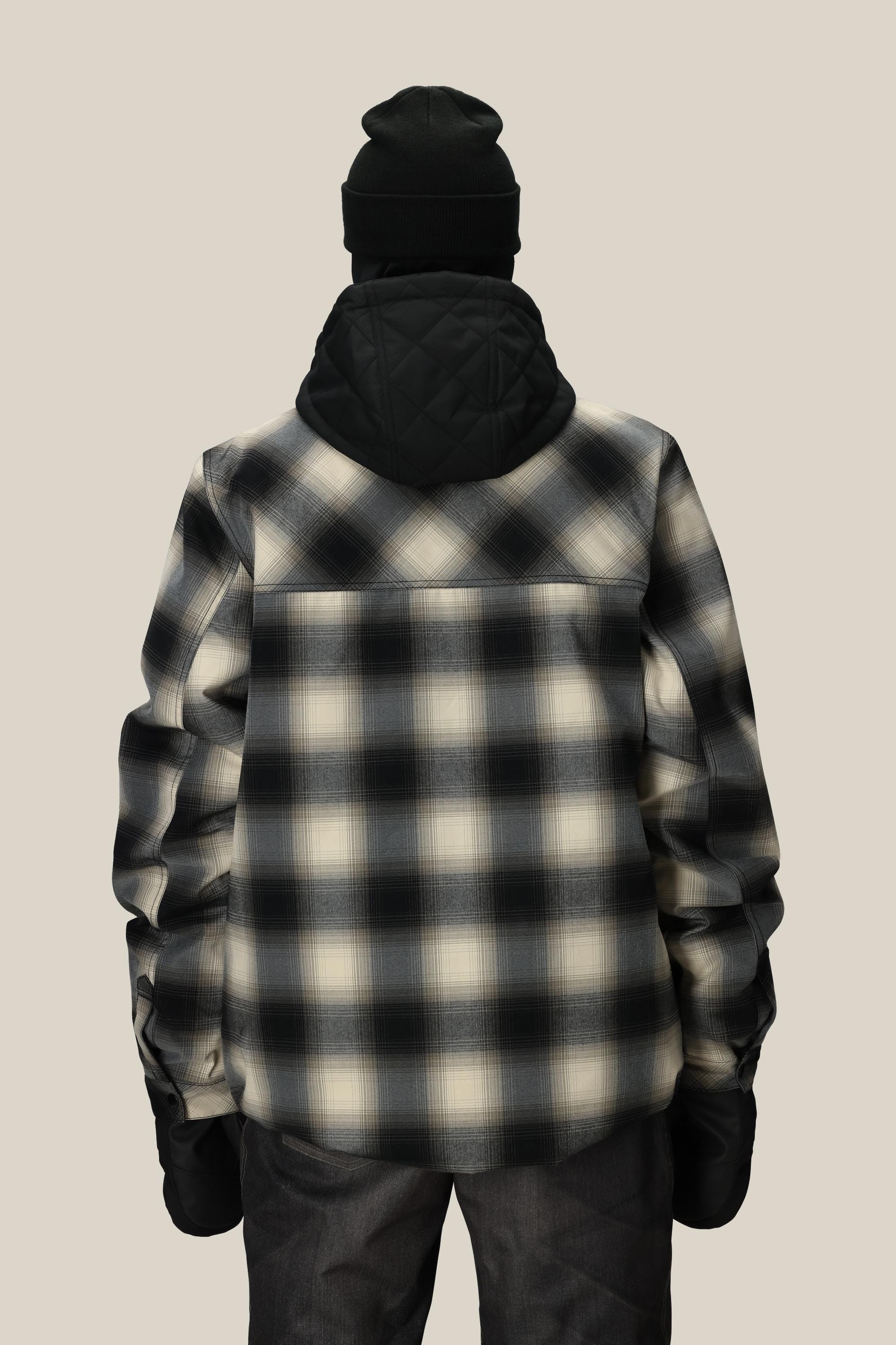 A person wearing a black beanie, black hood, and the 686 Mens Woodland Insulated Jacket by 686 in black and white plaid stands with their back to the camera against a plain beige background.