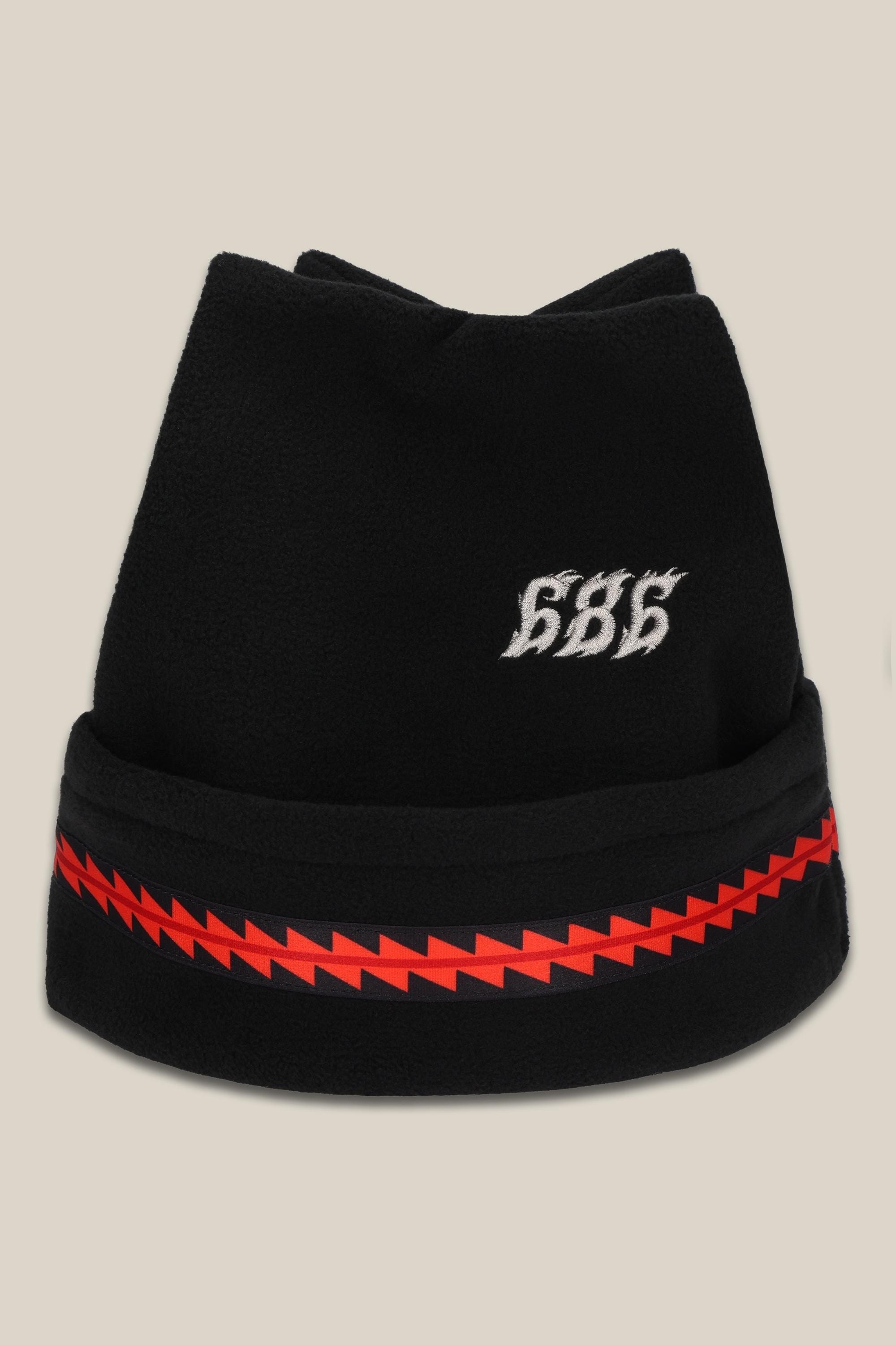 The 686 4 Points Fleece Hat is a black acrylic mens beanie featuring white 686 embroidery and a red zigzag stripe around the bottom, combining warmth and style.