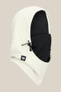 The 686 Waterproof Team Hood by 686 is a unisex facemask in white with a black face covering, crafted from soft polyester spandex. It features a drawstring adjustment and a small black logo tag, shown against a light beige background.