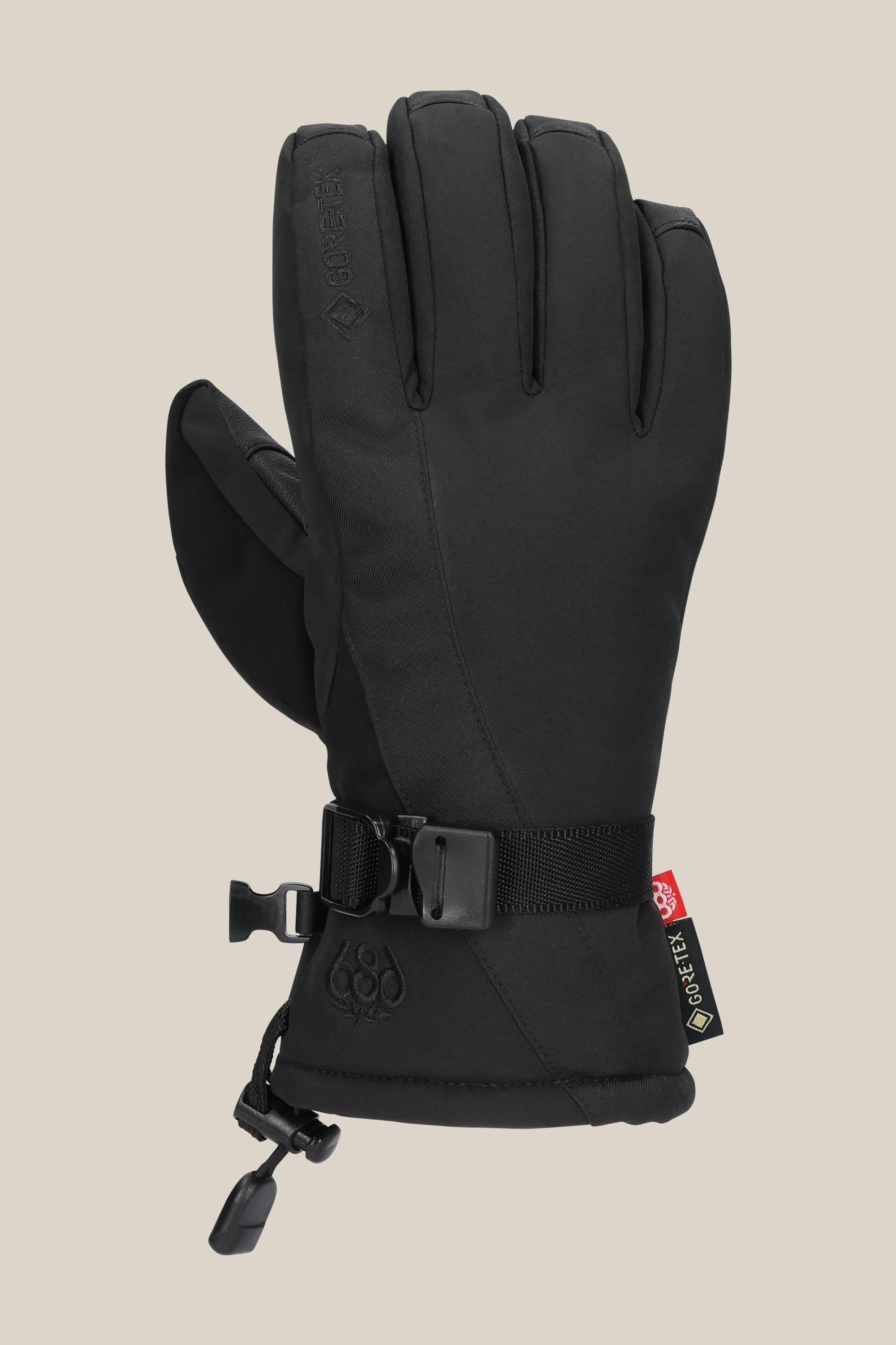 The 686 Womens GORE-TEX Linear Glove by 686 is shown in black with a wrist strap, adjustable cuff cord, and GORE-TEX tag on the side. This PU glove offers extra durability and winter protection against a plain beige background.