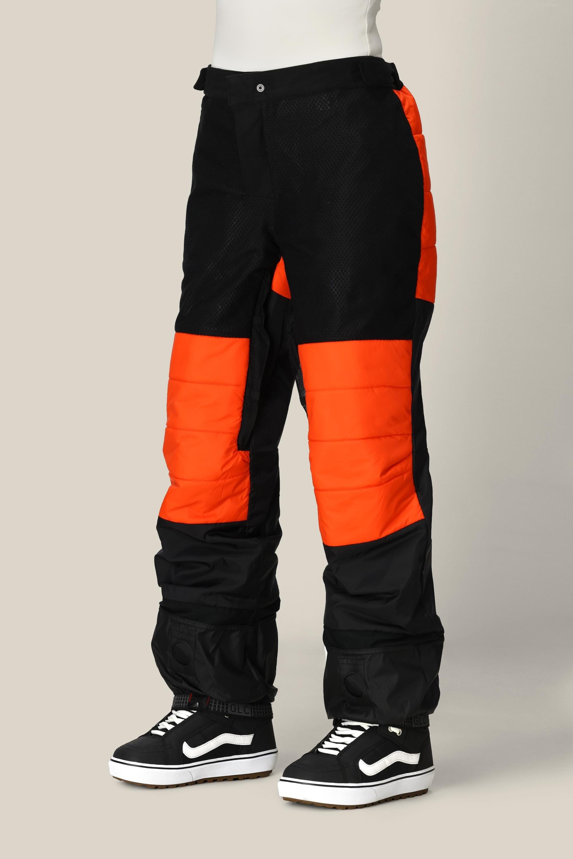A person wearing the 686 Women’s Geode Thermagraph® Pant by 686, paired with black Vans Old Skool sneakers, stands against a plain background.