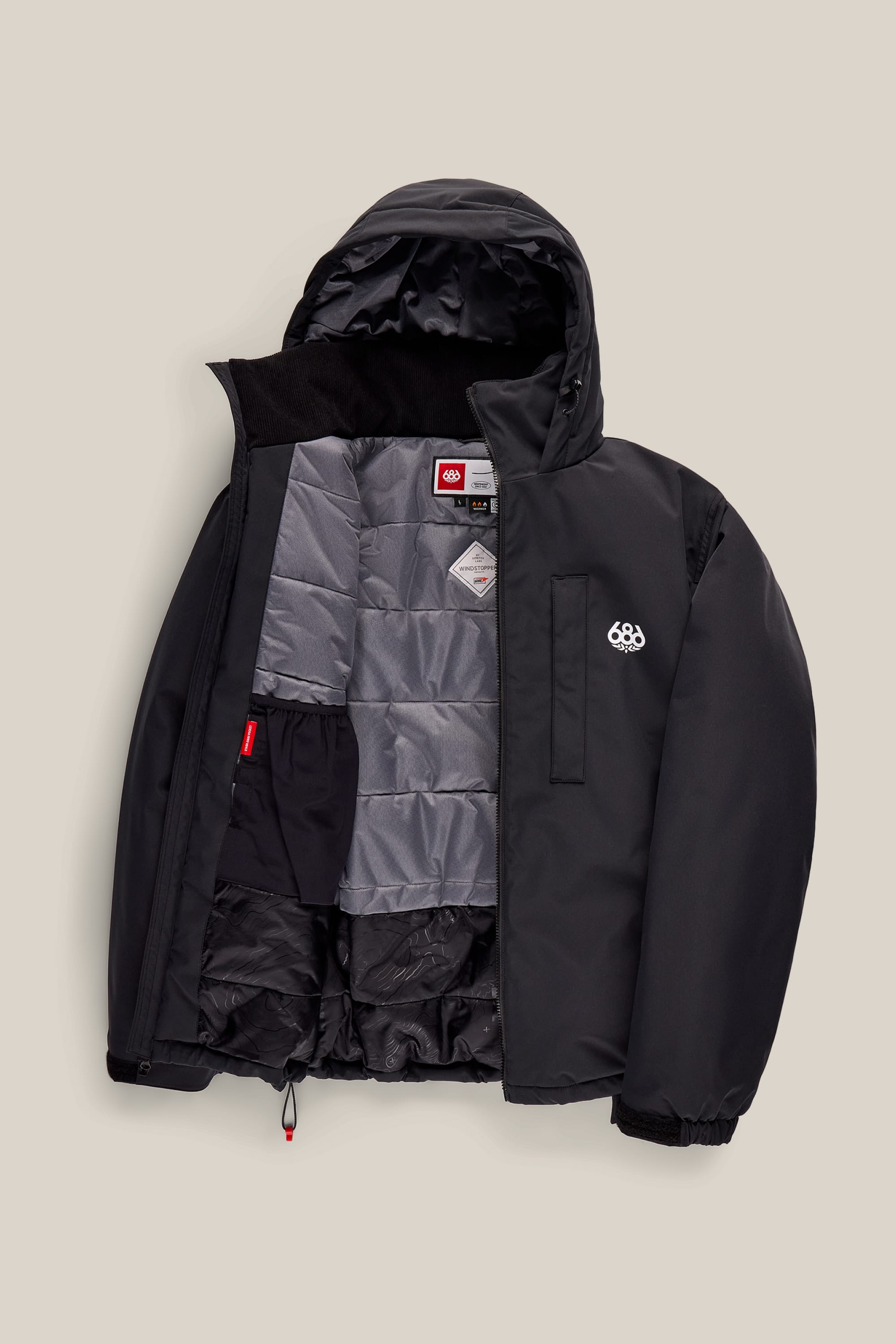 The 686 Men’s WINDSTOPPER® Guideline Insulated Jacket by GORE-TEX® LABS is displayed open, showcasing a gray quilted lining, zippered inner pocket, and interior brand tags. This black men’s jacket features a small white 686 logo on the chest and has elastic cuffs.