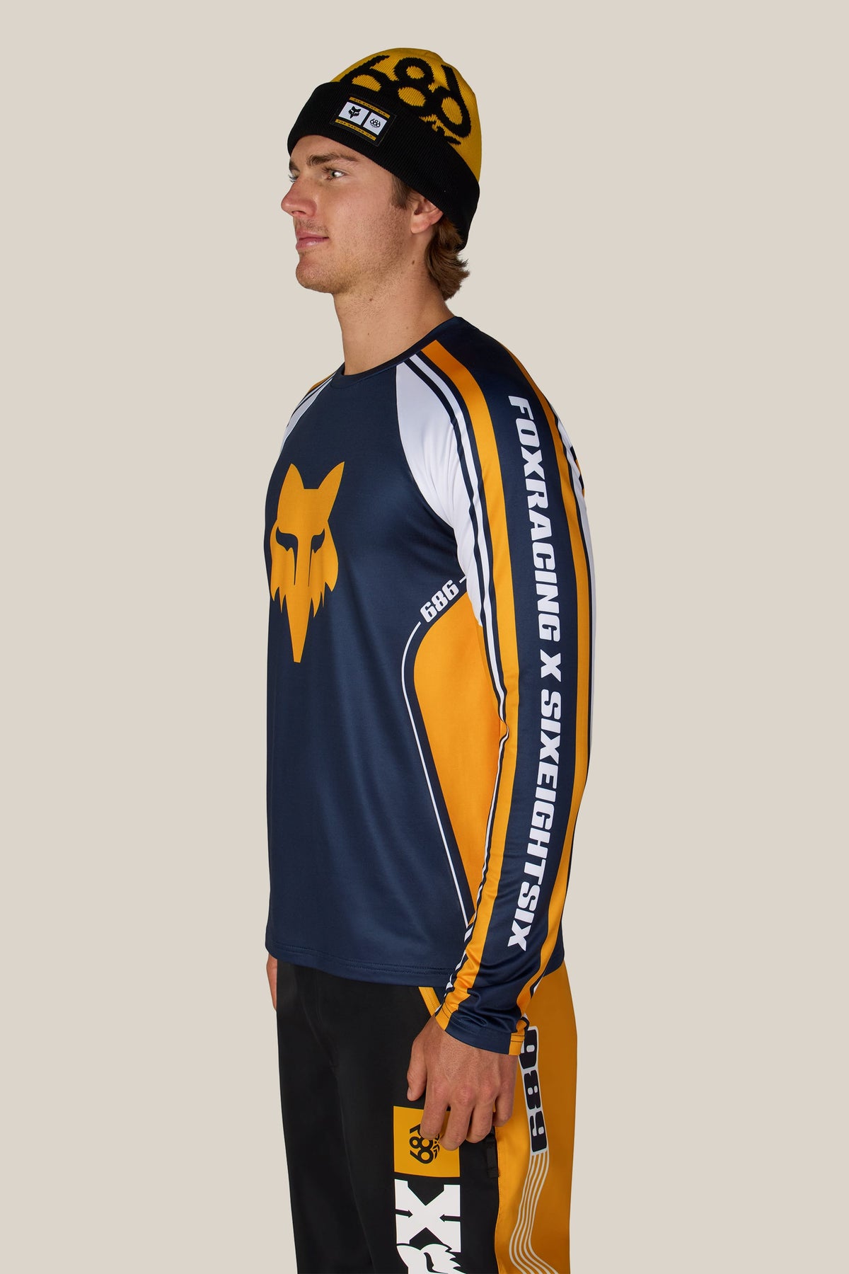 A man wearing a 686 beanie and a 686 Men’s Fox Racing Base Layer LS.