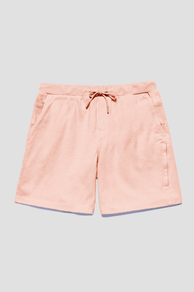 The 686 Mens Everywhere Double Knit Short by 686 in light pink features a casual drawstring waist, side pockets, and a right-side zipper detail, shown laid flat on a light gray background.