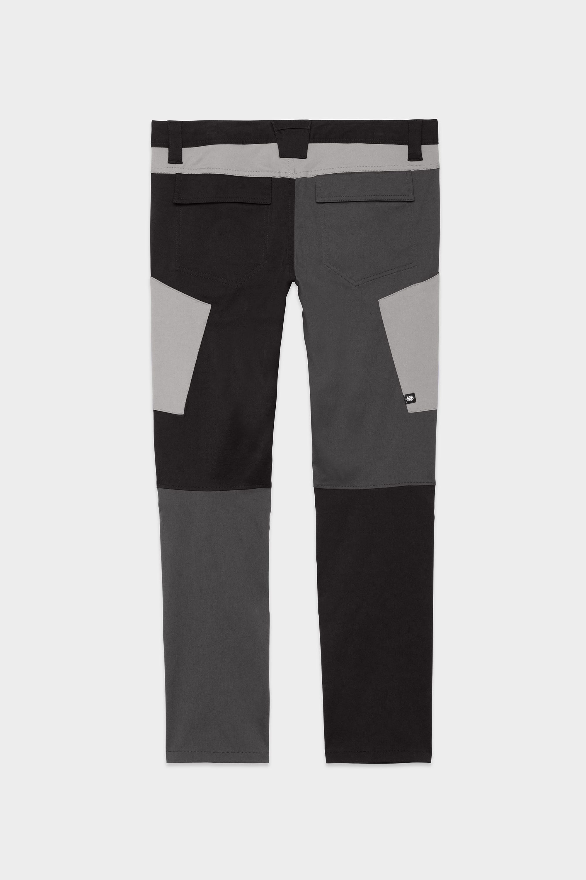 Back view of 686 Mens Anything Cargo Pant - Slim Fit by 686, in black and gray color-block, featuring two back pockets, belt loops, and adventure-inspired patch details on the back legs and waist.