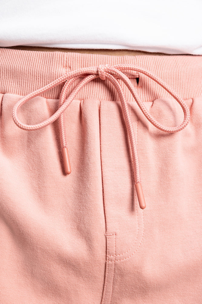 Close-up of 686 Mens Everywhere Double Knit Short by 686, featuring a matching drawstring bow at the waistband and paired with a slightly tucked-in white shirt.