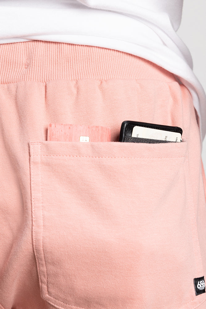 A close-up of the back pocket of 686 Mens Everywhere Double Knit Short in light pink, featuring a white object and black wallet partially visible, worn with a white shirt. Brand: 686.